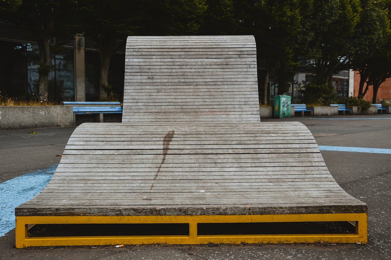 A wooden skate ramp with a distinctive curve in a city park, offering a unique urban design.