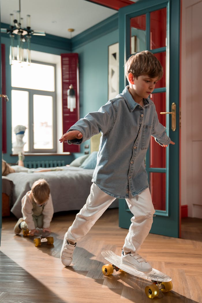 Two young brothers playing with skateboards inside a stylishly decorated bedroom.